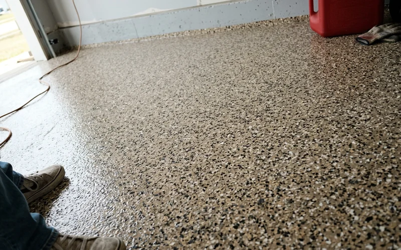 Detail of a full-broadcast flake garage floor showing colour blend and topcoat
