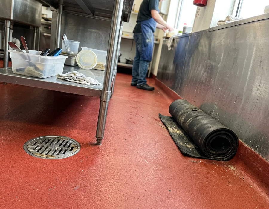 Commercial kitchen floor with non-slip broadcast and integral cove base